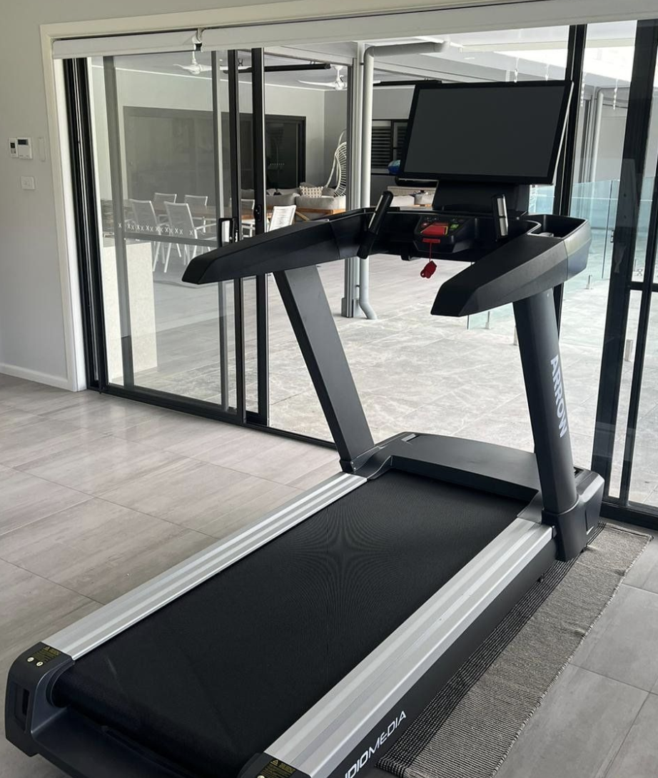 Technogym treadmill with digital console and black running belt